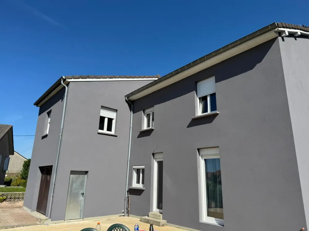 Maison à l'extérieur gris avec des garnitures blanchewebp
