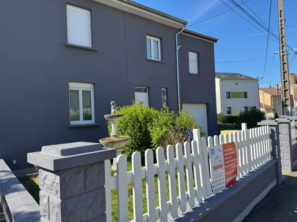 Photo d'une maison avec un jardin et barrières blancheswebp